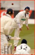 Shane Warne bowls in the cold wearing a woolly hat