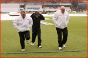 Umpires Davis & Erasmus with coach Mike Hasson in the rain