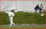 Spectators amongst the blown over chairs & ad boards